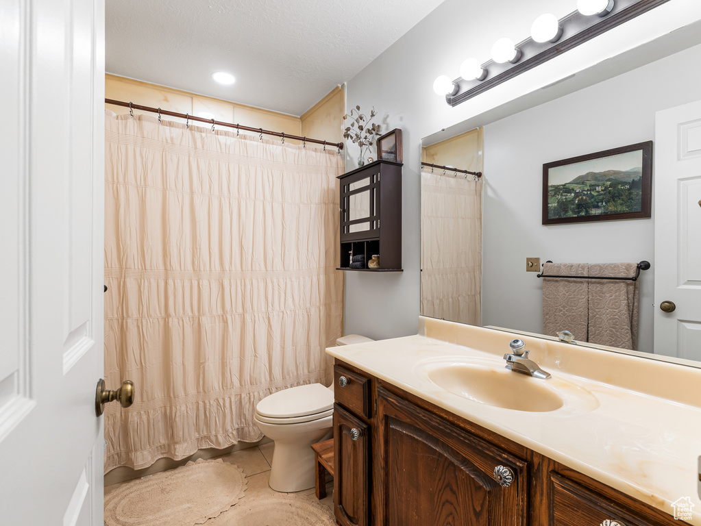 Bathroom featuring vanity, toilet, tile patterned floors, and curtained shower