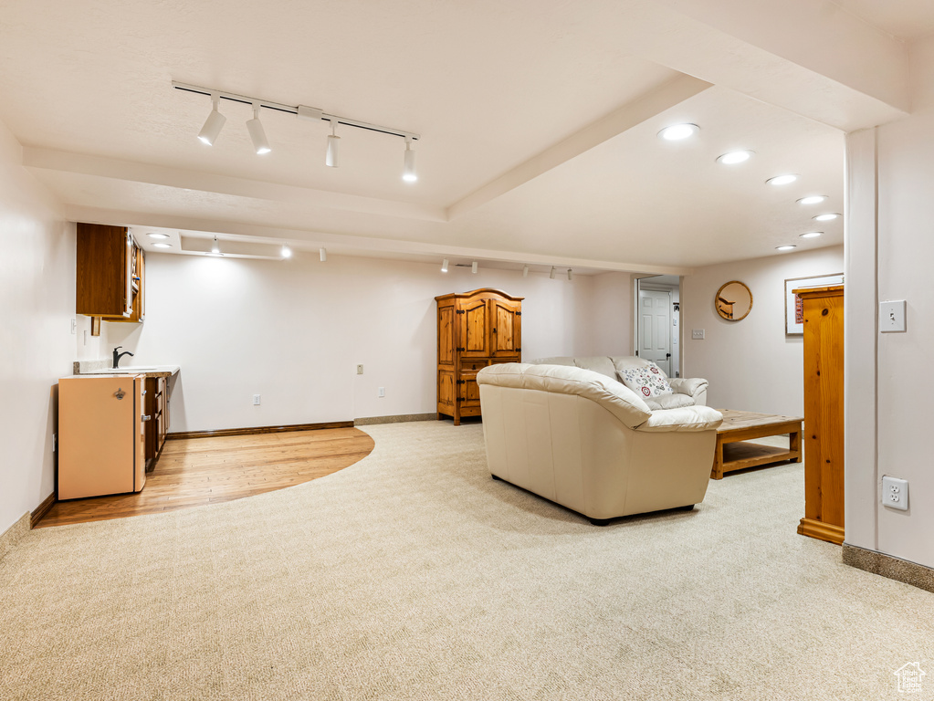 Living area featuring light colored carpet, track lighting, baseboards, and recessed lighting