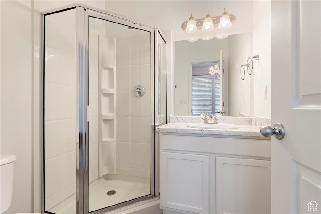 Full bath featuring a stall shower, vanity, and toilet