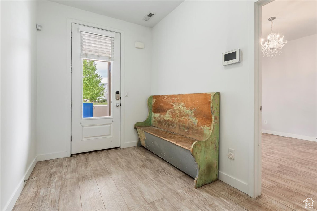 Sitting room with wood finished floors, a chandelier, and baseboards