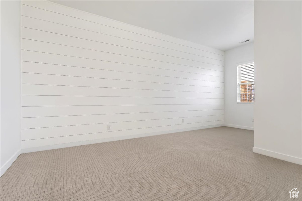 Unfurnished room with light colored carpet and baseboards