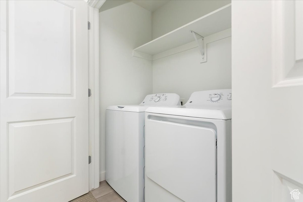Washroom featuring independent washer and dryer and light tile patterned floors