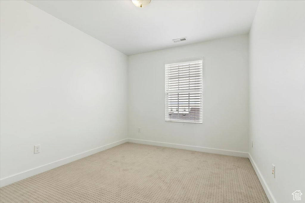Unfurnished room featuring light colored carpet and baseboards