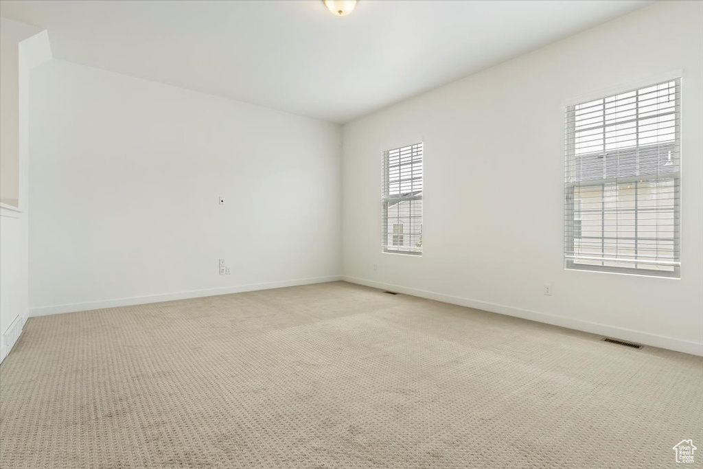Spare room with light carpet and baseboards