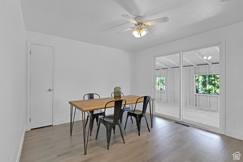 Dining room with light wood-type flooring, ceiling fan, and baseboards