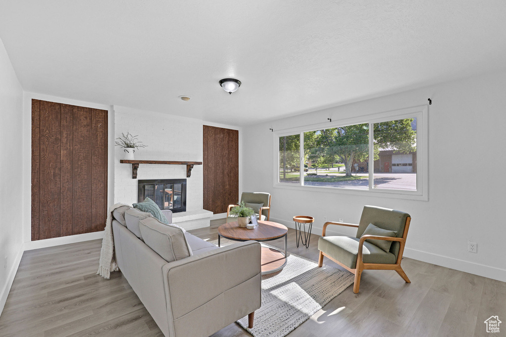 Living room with light wood-type flooring, baseboards, and a fireplace