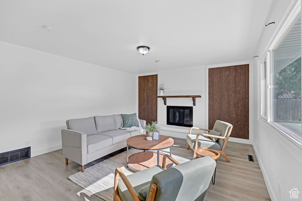 Living room with baseboards, light wood finished floors, and a fireplace