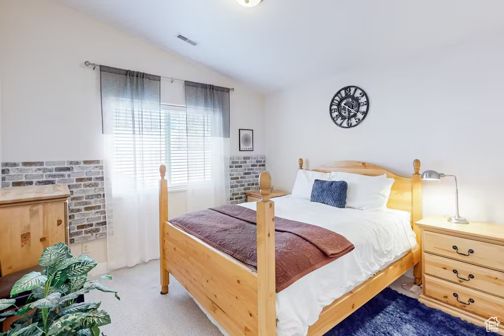 Carpeted bedroom featuring vaulted ceiling