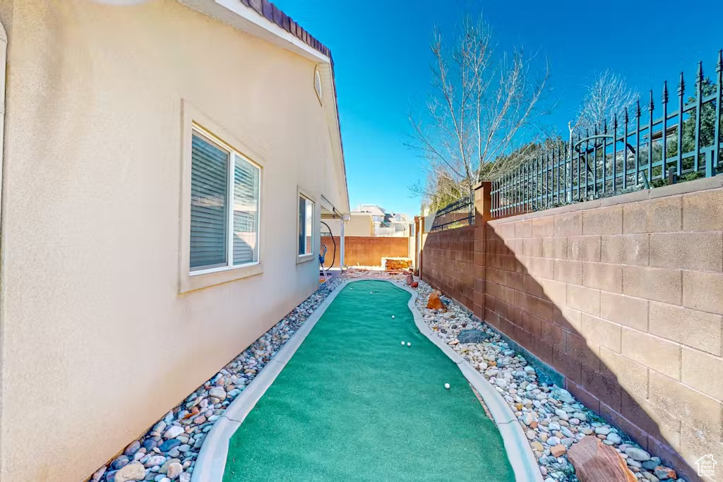 Fenced backyard with a putting green