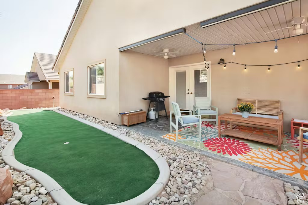 View of patio featuring ceiling fan, french doors, area for grilling, and a putting area