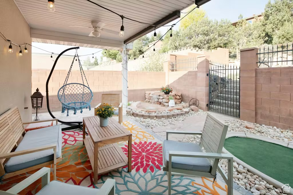 Fenced backyard featuring a ceiling fan and a patio area