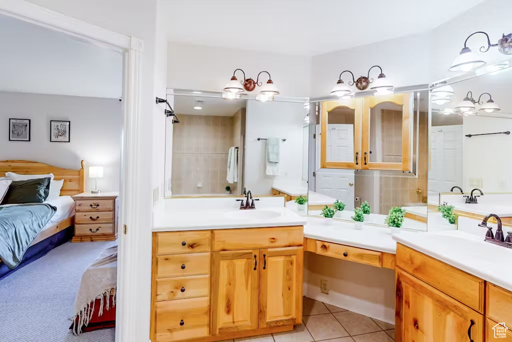 Ensuite bathroom with vanity and tile patterned flooring