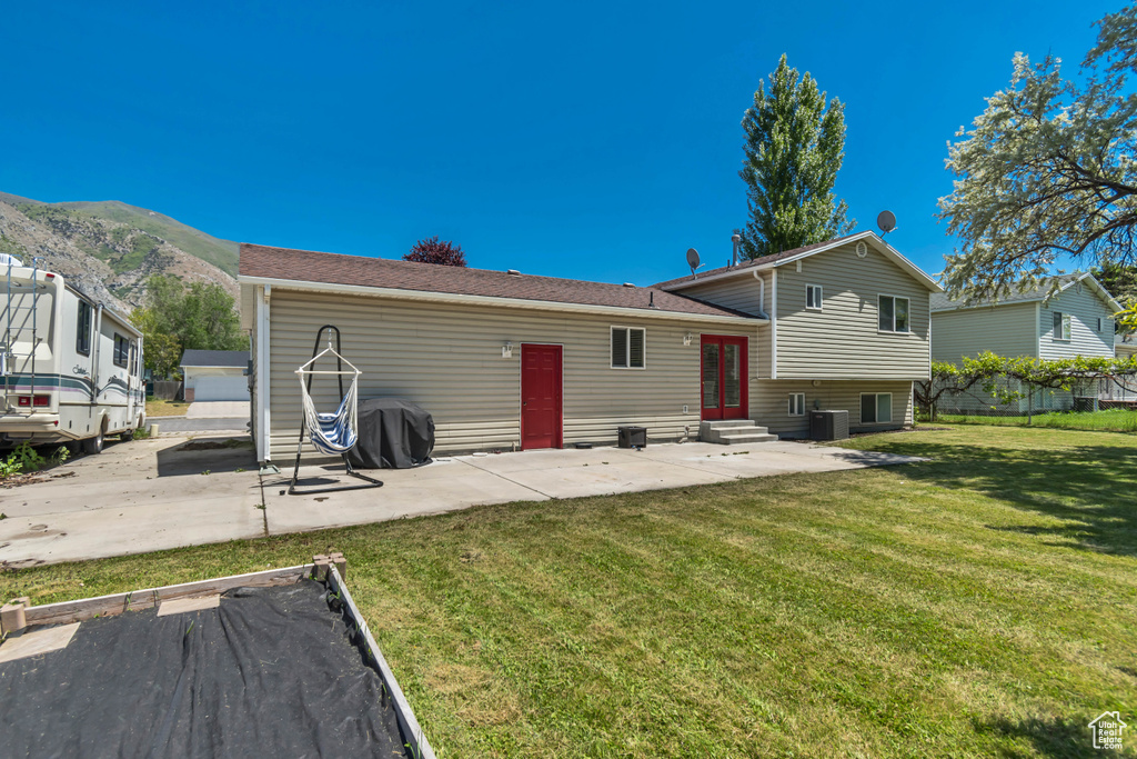 Back of house with entry steps, a mountain view, a patio, and central AC