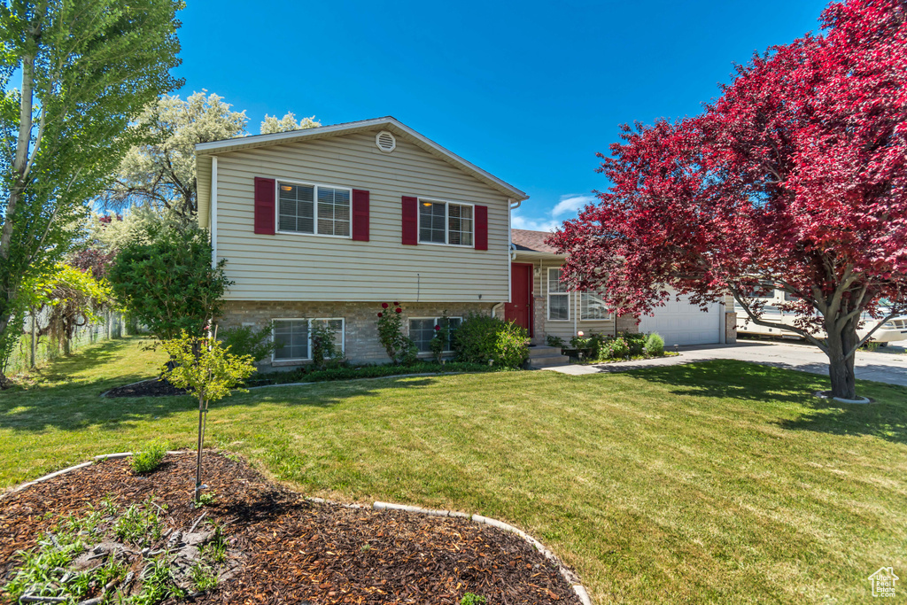 Tri-level home with a garage, a front yard, and driveway