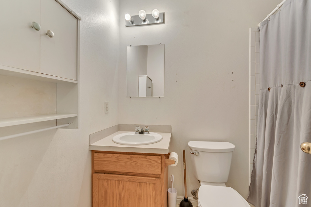 Bathroom featuring vanity, toilet, and a shower with shower curtain