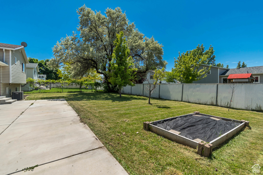 View of yard with central air condition unit and a patio area