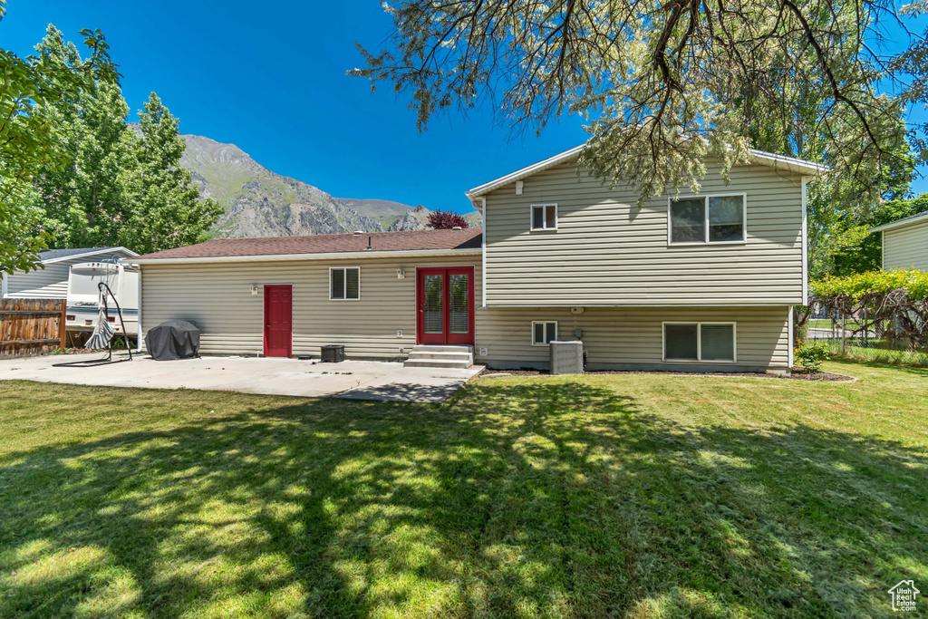 Rear view of house featuring a mountain view, a patio, french doors, central air condition unit, and entry steps
