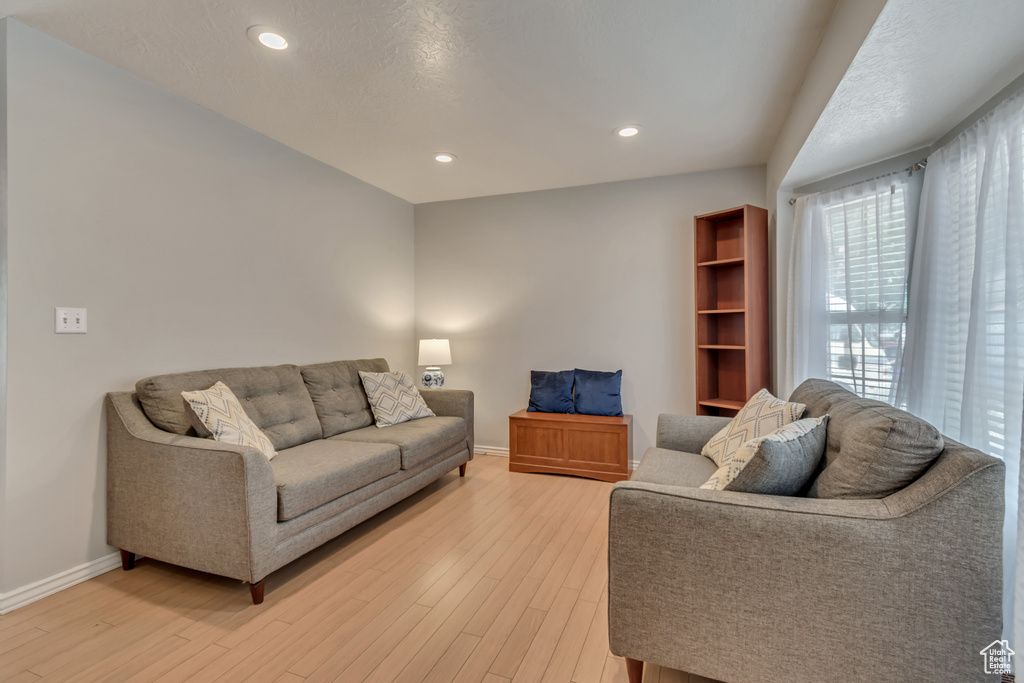 Living area with baseboards, light wood finished floors, and recessed lighting