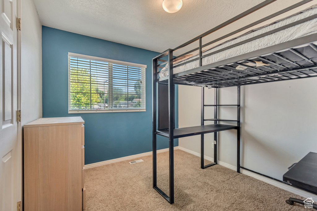 Unfurnished bedroom with carpet flooring, baseboards, and a textured ceiling