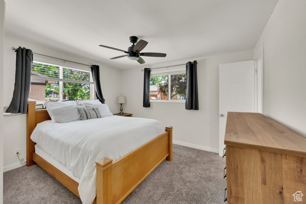 Bedroom featuring light colored carpet, baseboards, and ceiling fan