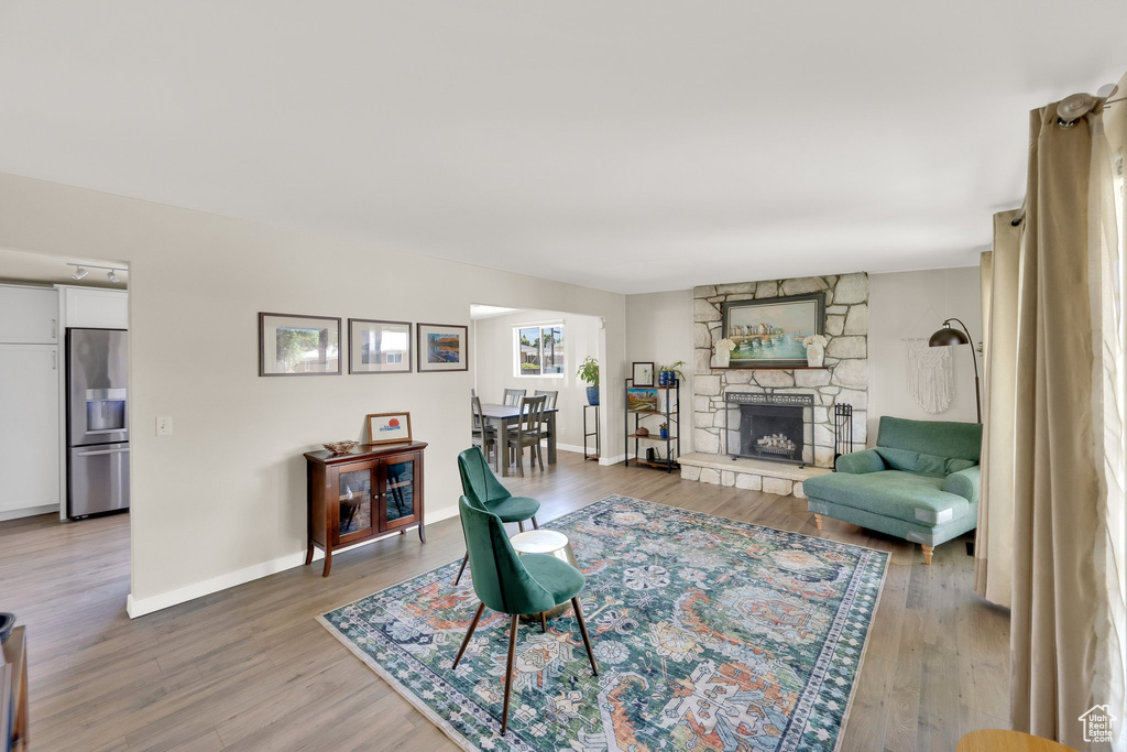 Living area with light wood finished floors, baseboards, and a fireplace