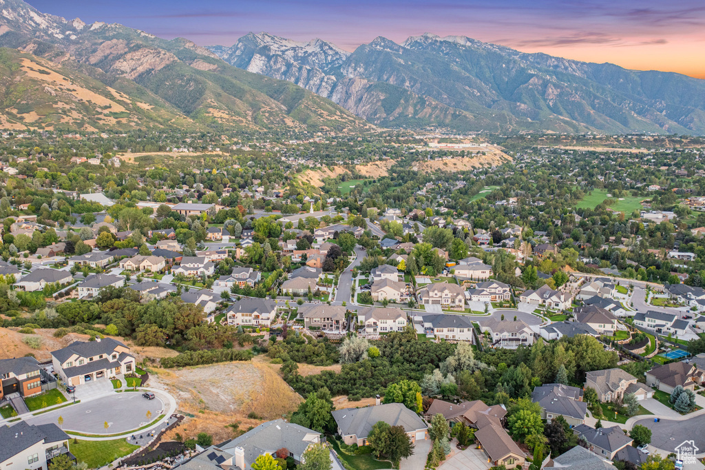 Aerial view of property's location with a mountain backdrop and nearby suburban area