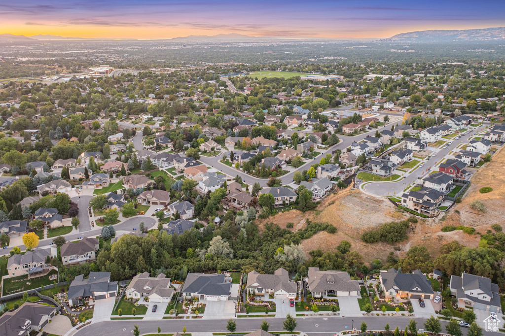 Aerial view of property and surrounding area with nearby suburban area and mountains