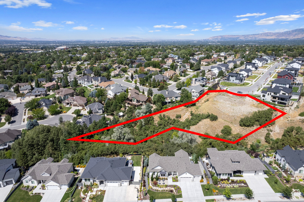 Aerial view of residential area with mountains and property parcel outlined