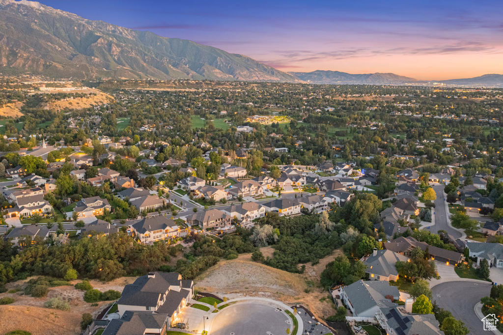 Aerial view of property and surrounding area with mountains and nearby suburban area