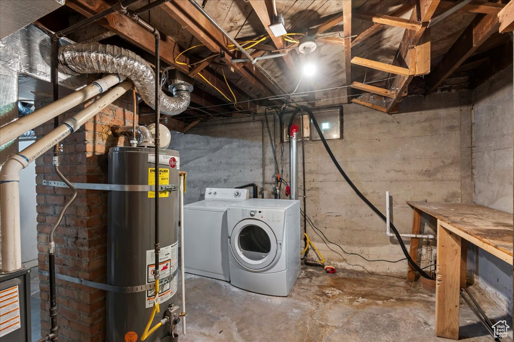 Unfinished basement featuring water heater and washer and clothes dryer