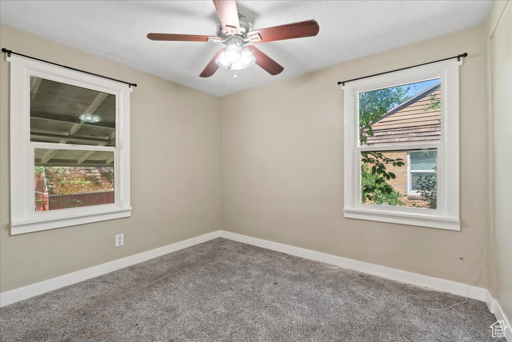 Spare room featuring carpet, baseboards, and a ceiling fan