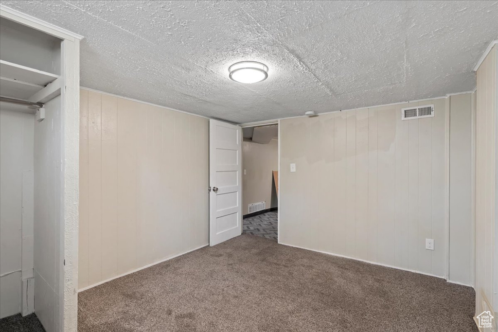 Unfurnished bedroom with carpet floors and wood walls