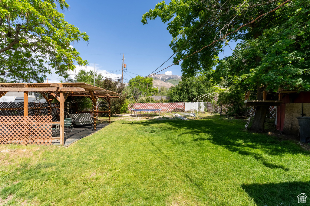 View of yard featuring a trampoline, a pergola, and a patio area