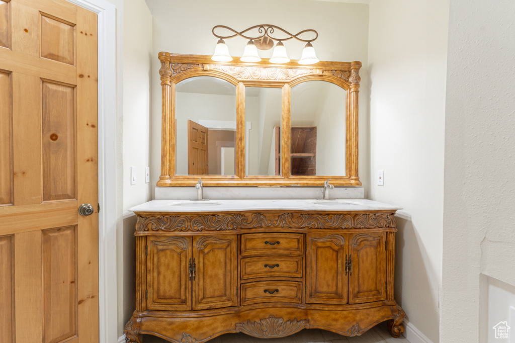 Full bath featuring double vanity and baseboards