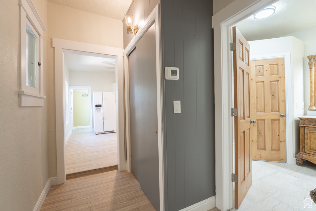 Corridor featuring baseboards and light wood-style flooring