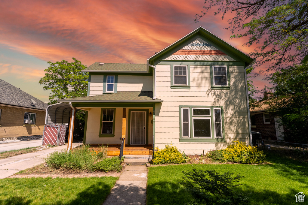 Victorian home with covered porch, a carport, and driveway