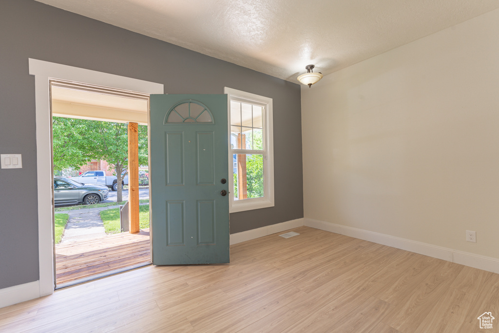 Entryway with baseboards and light wood-style flooring