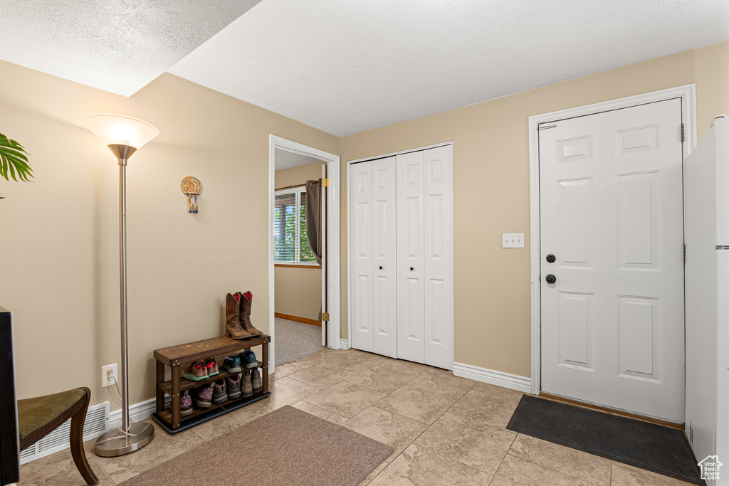 Foyer entrance featuring baseboards and light tile patterned floors