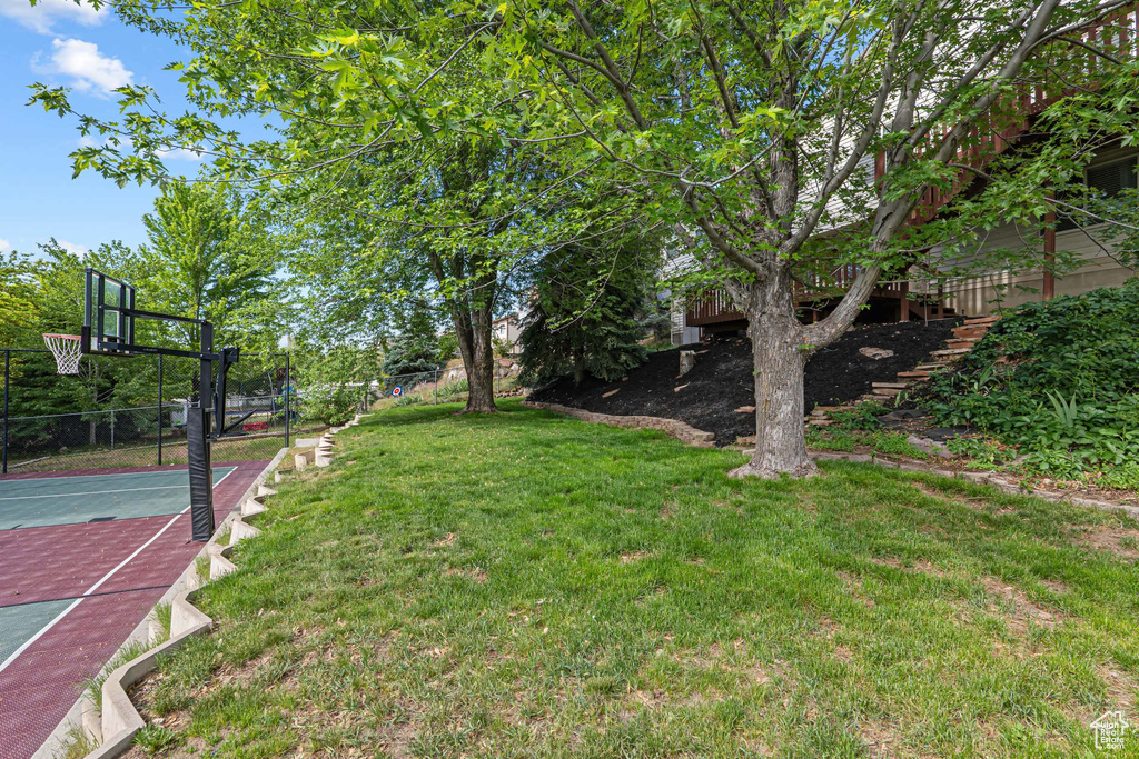 View of yard featuring basketball hoop and stairs