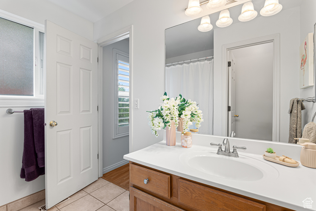 Bathroom featuring tile patterned floors, vanity, and baseboards