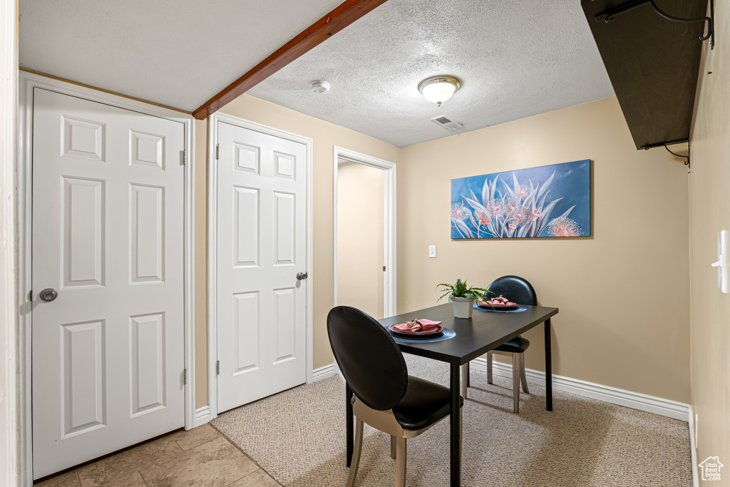 Office featuring baseboards, a textured ceiling, and light colored carpet
