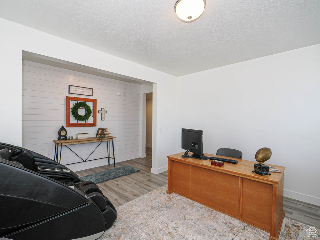 Office space with baseboards, wood finished floors, and a textured ceiling