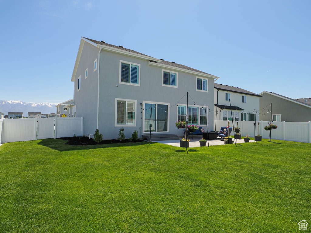 Back of property with an outdoor hangout area, a patio area, stucco siding, a gate, and a mountain view