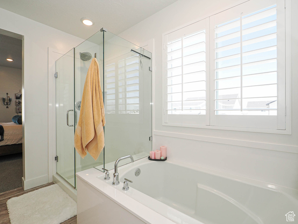 Ensuite bathroom featuring a garden tub, a stall shower, and recessed lighting