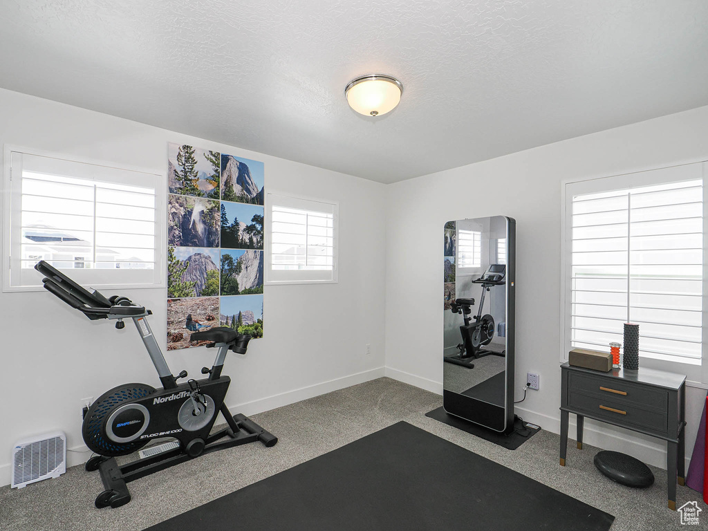 Workout room with baseboards and a textured ceiling