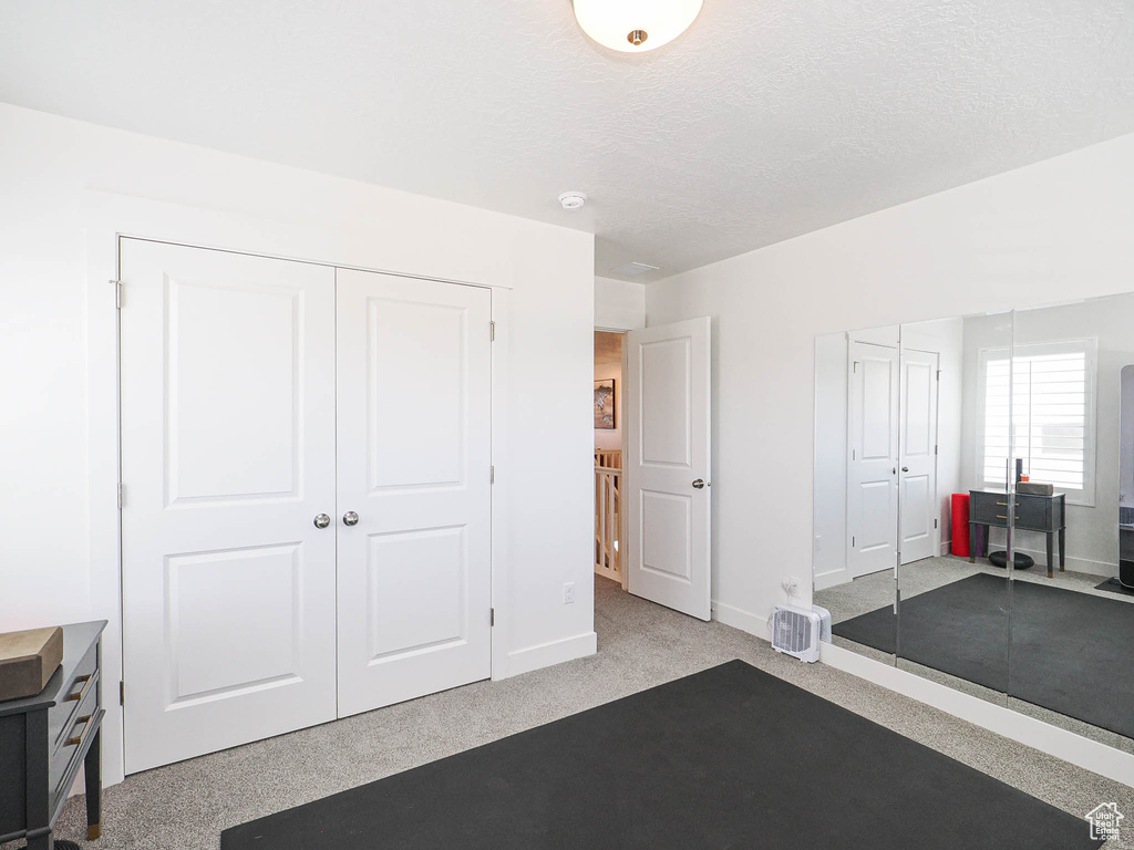 Carpeted home office with a textured ceiling and baseboards