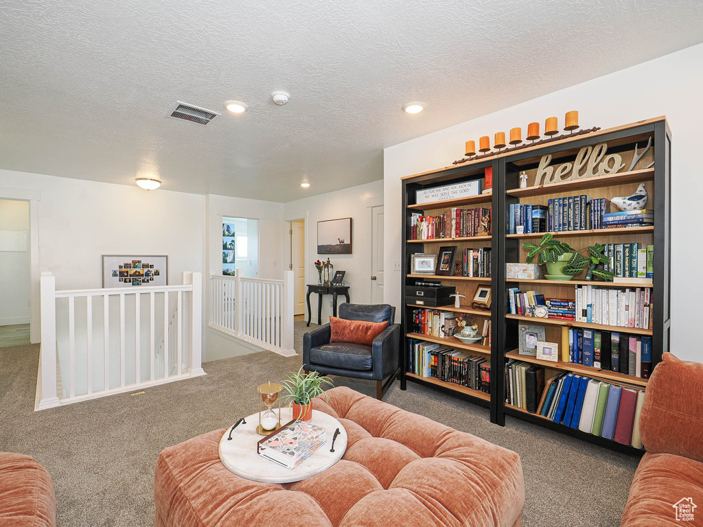 Sitting room featuring an upstairs landing, carpet, recessed lighting, and a textured ceiling