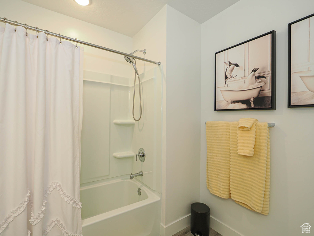 Full bath with baseboards and shower / bath combo