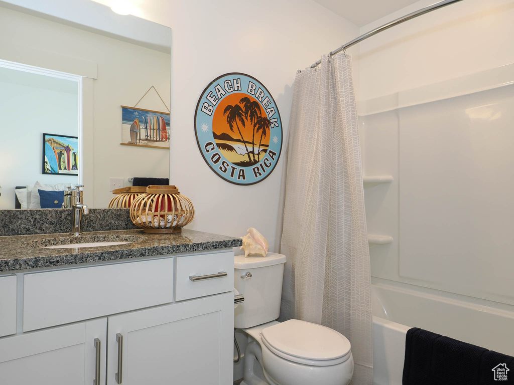 Full bathroom featuring vanity, toilet, and shower / bath combo with shower curtain