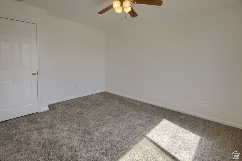 Spare room with carpet, ceiling fan, and baseboards